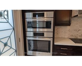 A modern kitchen with a stainless steel oven and microwave.