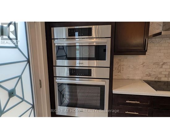 A modern kitchen with a stainless steel oven and microwave.