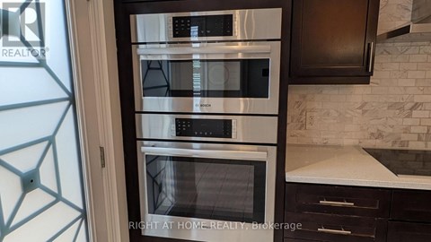 A modern kitchen with a stainless steel oven and microwave.