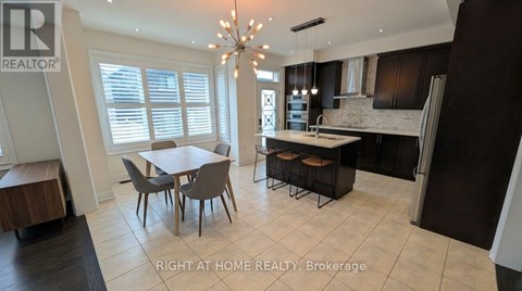 A well-lit kitchen with a dining table and chairs.