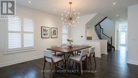 A dining room with a wooden table and chairs.