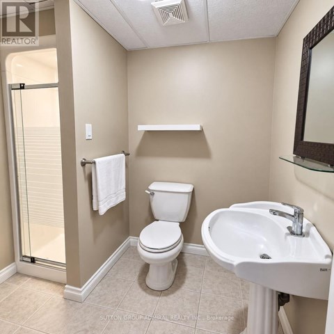 A white toilet sits next to a sink in a bathroom.
