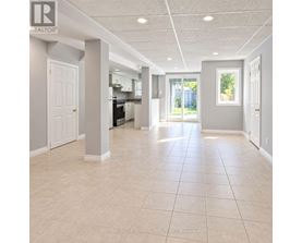 A spacious room with tiled flooring and white walls.