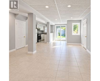 A spacious room with tiled flooring and white walls.