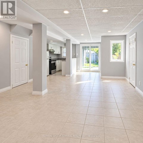A spacious room with tiled flooring and white walls.