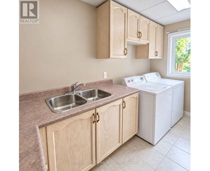 A kitchen with wooden cabinets and a white dishwasher.