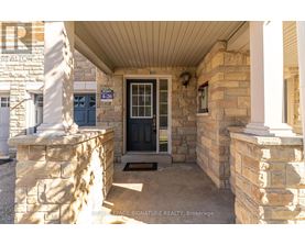 The entrance to a building with a stone pillar and a black door.