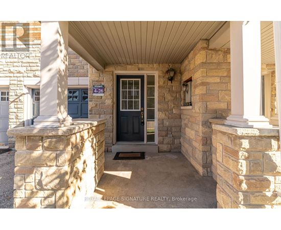 The entrance to a building with a stone pillar and a black door.