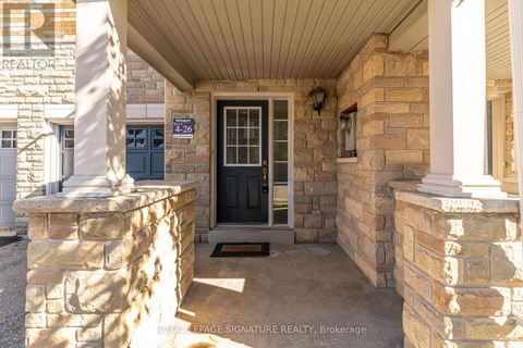 The entrance to a building with a stone pillar and a black door.