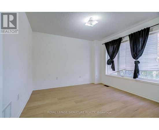 A room with wooden flooring and white walls.