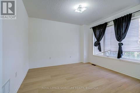 A room with wooden flooring and white walls.