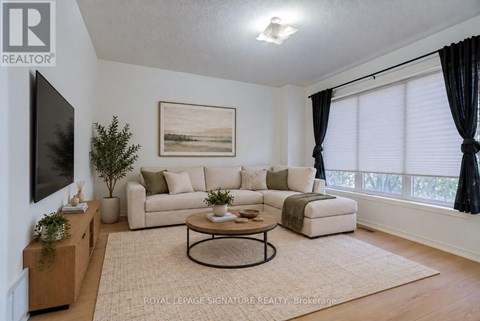 A living room with a couch, a coffee table, and a painting on the wall.