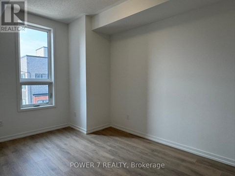 A room with a window and wooden flooring is for sale.