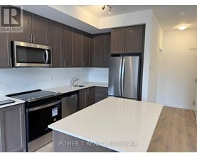 A kitchen with a white counter top and stainless steel appliances.