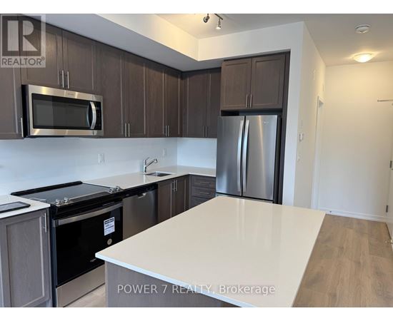 A kitchen with a white counter top and stainless steel appliances.