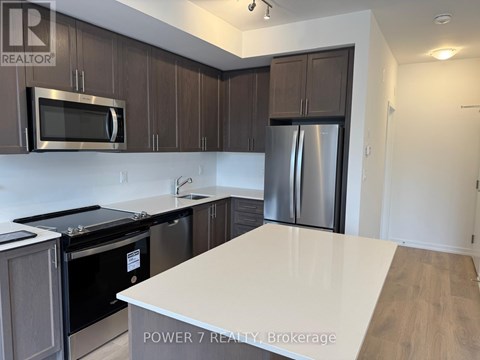 A kitchen with a white counter top and stainless steel appliances.