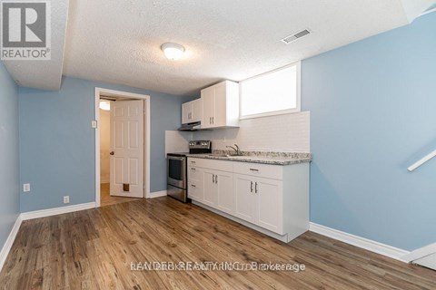 A kitchen with white cabinets and a wooden floor.