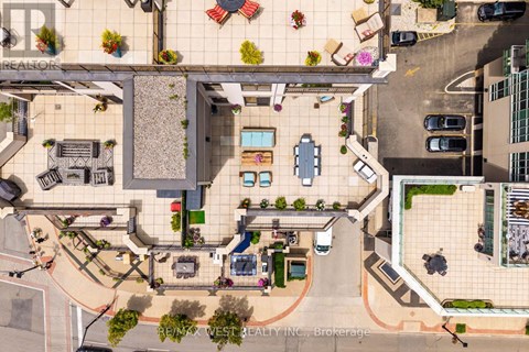 A bird's eye view of a courtyard with a pool and a building with the sign "REALTOR".