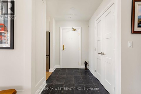 A hallway with a brokerage sign on the wall.