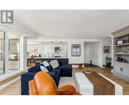 A living room with a blue couch and a brown leather chair.