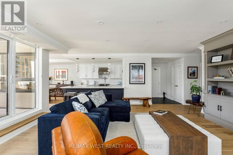 A living room with a blue couch and a brown leather chair.