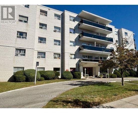 A large white apartment building with a sign that says REALTOR.