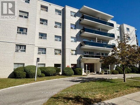 A large white apartment building with a sign that says REALTOR.