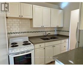 A kitchen with white cabinets and a stove top oven.
