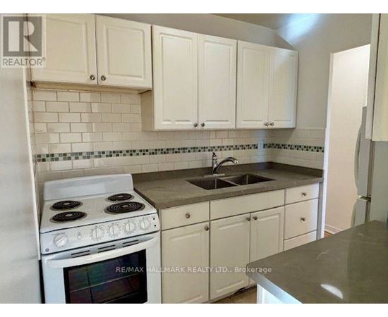 A kitchen with white cabinets and a stove top oven.