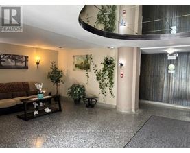 A living room with a couch, a coffee table, and a plant.