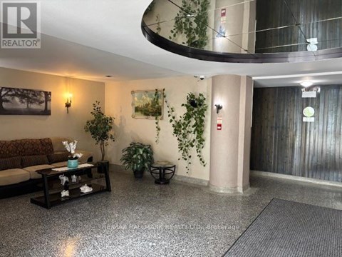 A living room with a couch, a coffee table, and a plant.