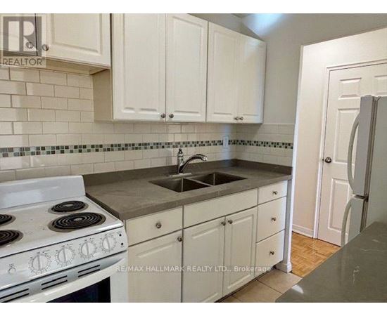 A kitchen with white cabinets and a white stove top oven.