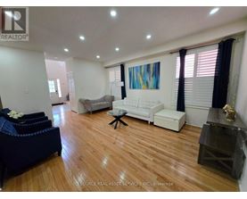A living room with a white couch and a blue ottoman.