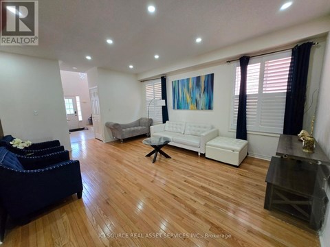 A living room with a white couch and a blue ottoman.