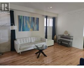 A living room with a white couch and a glass coffee table.