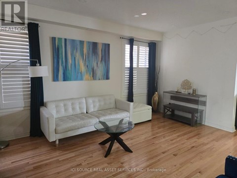 A living room with a white couch and a glass coffee table.