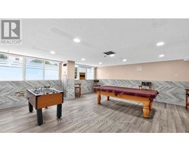 A room with a pool table and a foosball table.