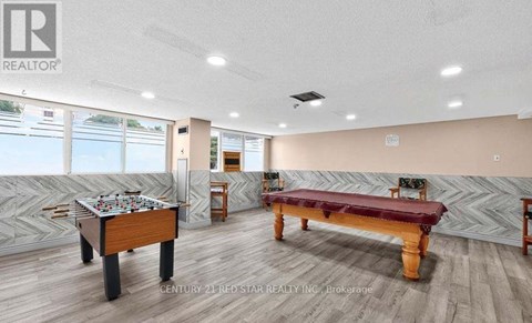 A room with a pool table and a foosball table.