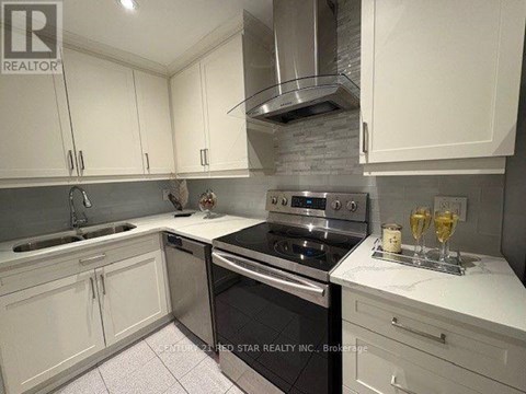 A kitchen with white cabinets and a black stove top oven.