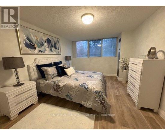A bedroom with a bed, nightstand, and a painting on the wall.