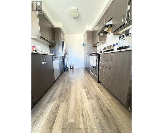 A kitchen with wood flooring and dark cabinets.