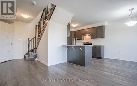 A spacious kitchen with a staircase on the left side.