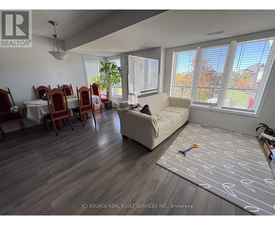 A living room with a couch, chairs, and a dining table.