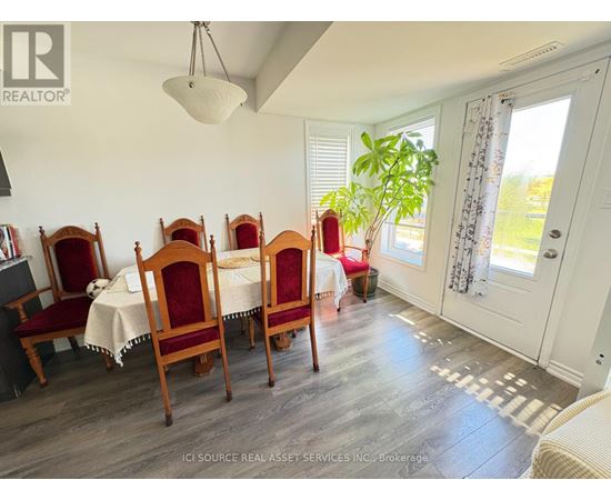 A dining room with a table set for six with chairs with red covers.