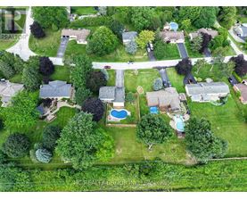 A bird's eye view of a neighborhood with a pool and a road.
