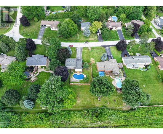 A bird's eye view of a neighborhood with a pool and a road.