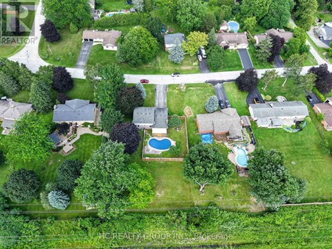 A bird's eye view of a neighborhood with a pool and a road.
