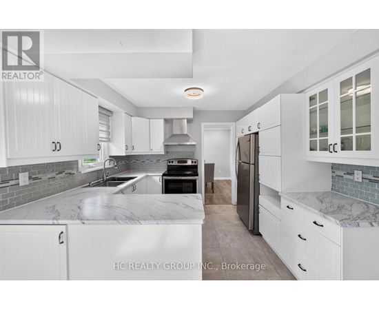 A modern kitchen with white cabinets and a marble countertop.