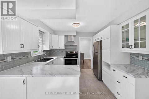 A modern kitchen with white cabinets and a marble countertop.