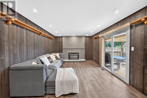 A modern living room with a grey sofa and a fireplace.